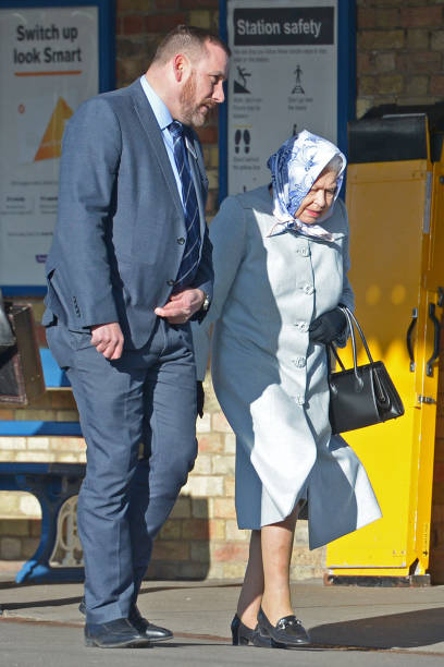 Queen Elizabeth II walks alongside station manager Graeme Pratt as she arrives at King's Lynn railway station in Norfolk ahead of boarding a train as...