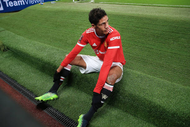 Raphael Varane of Manchester United sits on the end of the pitch during the Emirates FA Cup Third Round match between Manchester United and Aston...