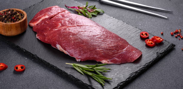 raw fresh chuck roll steak with herbs and salt on a cutting board picture