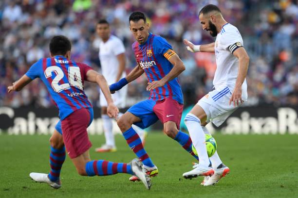 Real Madrid's French forward Karim Benzema vies with Barcelona's Spanish midfielder Sergio Busquets during the Spanish League football match between...