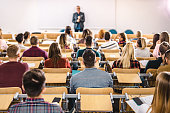 Rear view of large group of students on a class at lecture hall.