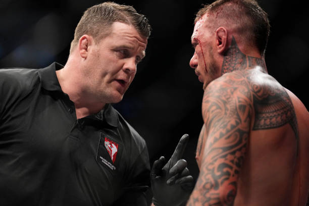Referee Marc Goddard talks to Renato Moicano of Brazil before the fifth round of his 160-pound catchweight fight against Rafael Dos Anjos of Brazil...