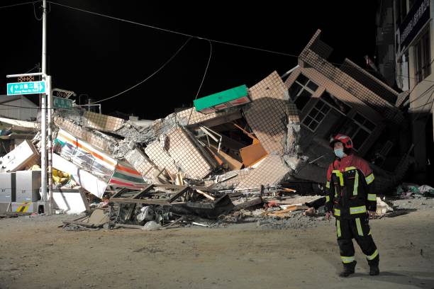 Rescuer walks past a collapsed building after an earthquake at Yuli Township in Hualien county, eastern Taiwan on September 18, 2022. - A strong...