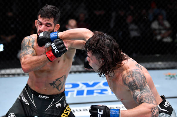 Ricky Simon punches Raphael Assuncao of Brazil in their bantamweight fight during the UFC Fight Night event at UFC APEX on December 18, 2021 in Las...