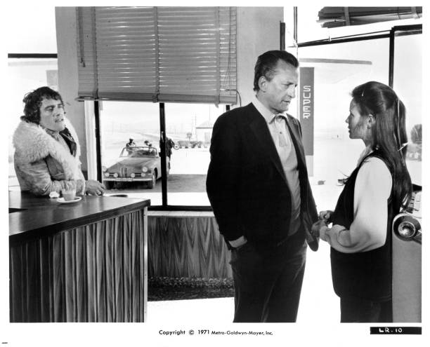 Robert Coleby watches as George C Scott talks with Trish Van Devere in a scene from the film 'The Last Run' 1971