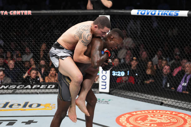 Robert Whittaker of Australia attempts to take down Israel Adesanya of Nigeria in their UFC middleweight championship fight during the UFC 271 event...