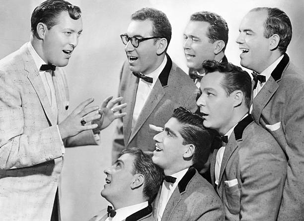 Rock and roll band Bill Haley & His Comets sings in matching tuxedos.
