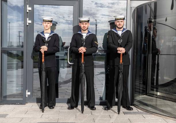 Royal Navy personnel on umbrella duty as they wait at RAF Marham for the arrival of Queen Elizabeth II where she inspects the new integrated training...