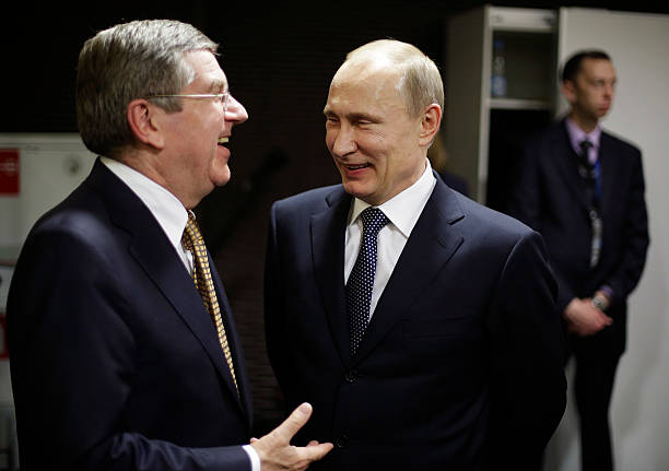 Russian President Vladimir Putin talks with International Olympic Committee President Thomas Bach in the presidential lounge before the start of the...