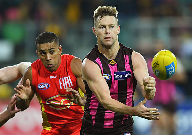 Sam Mitchell of the Hawks handballs during the round 14 AFL match between the Hawthorn Hawks and the Gold Coast Suns at Aurora Stadium on June 26,...