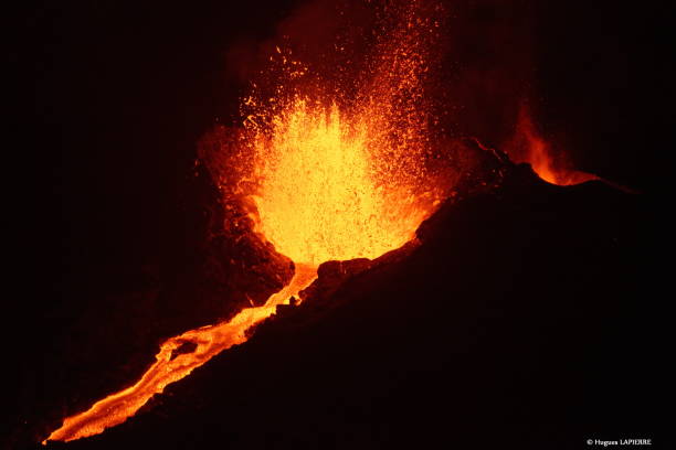 Scenic view of lava with mountain against sky at night