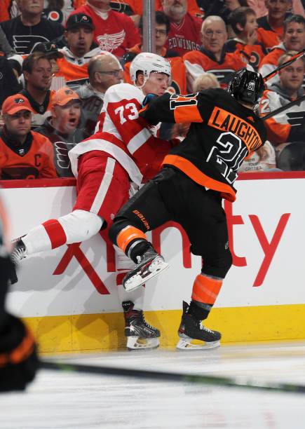 Scott Laughton of the Philadelphia Flyers checks Adam Erne of the Detroit Red Wings into the boards on November 29, 2019 at the Wells Fargo Center in...