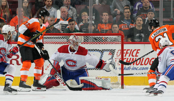 Scott Laughton of the Philadelphia Flyers takes a shot on goal against Carey Price of the Montreal Canadiens with Michael Raffl on February 20, 2018...