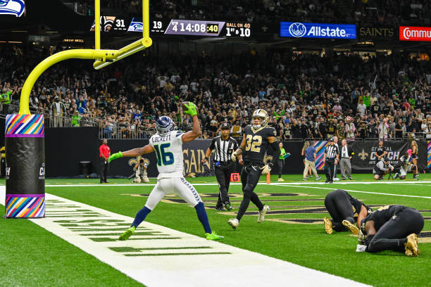 Seattle Seahawks wide receiver Tyler Lockett spikes the ball to celebrate his touchdown reception early in the fourth quarter during the football...