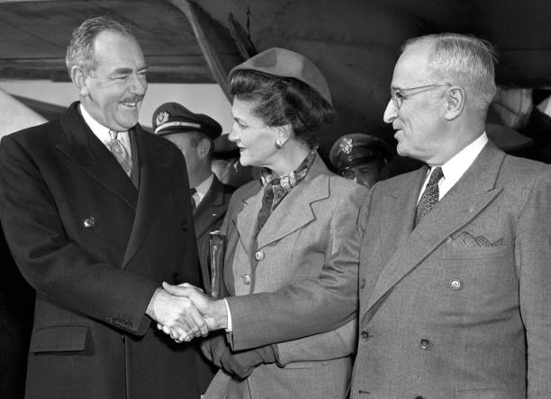 Secretary of State, Dean Acheson, is greeted by Mrs. Acheson and President Truman as he arrived at Washington Airport from Europe.
