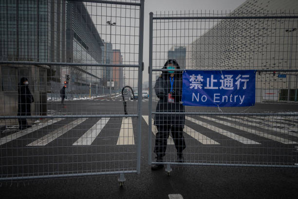 Security guard closes the gate in the fence that delimitates the area not accessible to the general public, that will host Beijing 2022 Winter...