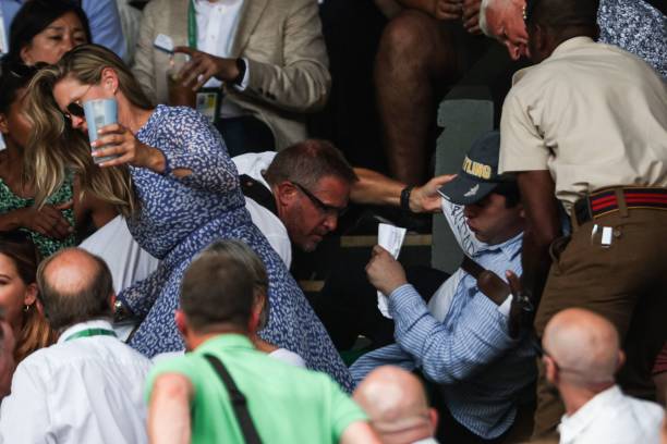 Security personnel and spectators remove a protester from the stands during their men's singles final tennis match between Serbia's Novak Djokovic...
