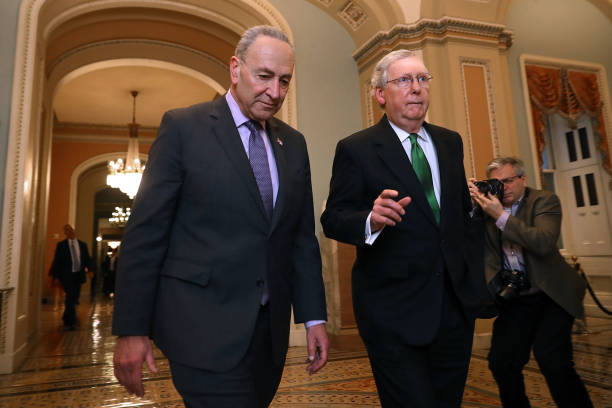 Senate Minority Leader Charles Schumer and Senate Majority Leader Mitch McConnell walk side-by-side to the Senate Chamber at the U.S. Capitol...