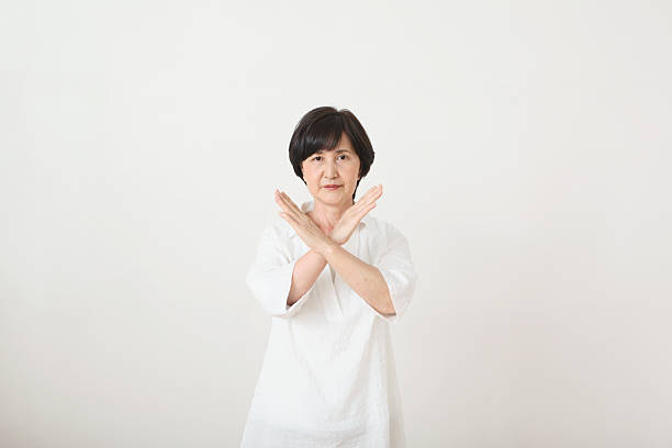 senior adult japanese woman against white wall - angry old asian lady stock pictures, royalty-free photos & images