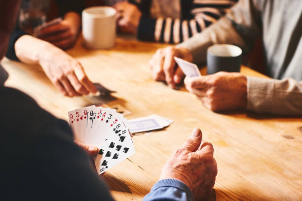 personas mayores jugando a las cartas - naipes fotografías e imágenes de stock