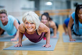 Senior Woman in Fitness Class in a Plank Pose Smiling stock photo