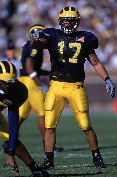 Larry Foote of the Michigan Wolverines directs his team during the game against the Illinois Fighting Illini at the Michigan Stadium in Ann Arbor,...