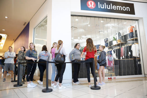 shoppers form a line outside of lululemon a clothing store to catch picture