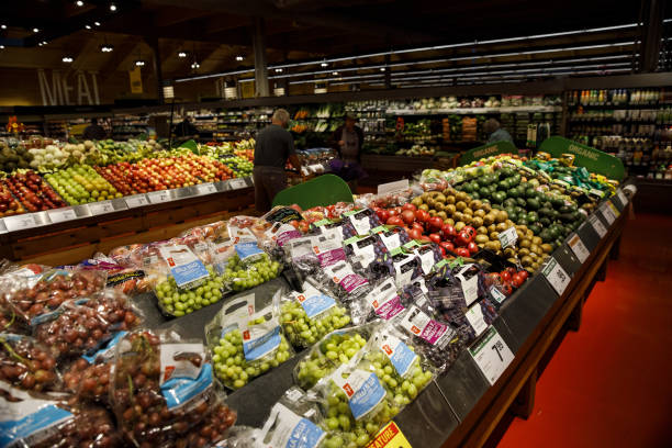 Shoppers walk through produce aisles at a grocery store 