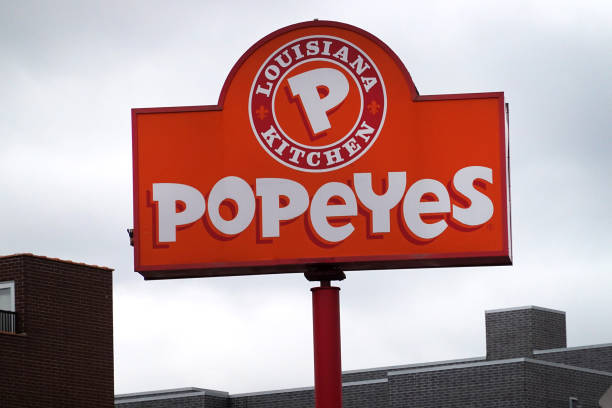 sign hangs outside of a popeyes louisiana kitchen restaurant on may picture