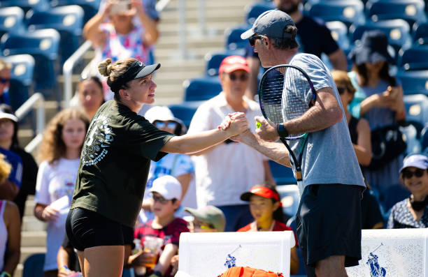 Simona Halep of Romania shakes hands with former coach Darren Cahill during practice ahead of the US Open Tennis Championships at USTA Billie Jean...