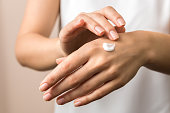 skincare. close up view of woman hand moisturising them with cream. skincare