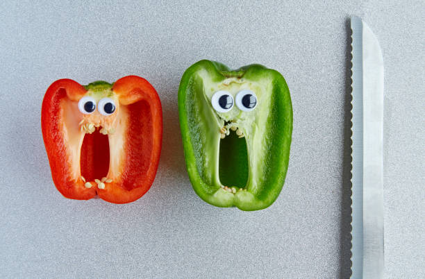 Sliced Pepper with sticky eyes screaming with knife