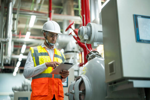 smart professional engineer using touch pad while standing in boiler picture