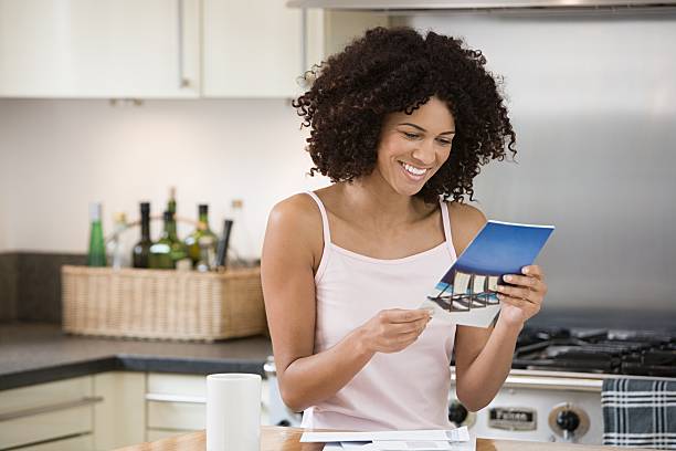 Smiling woman reading a brochure in kitchen