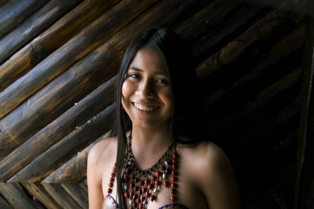 Smiling young Guarani woman against bamboo wall, Misahualli,