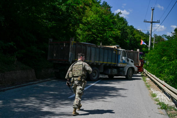 Soldier serving in Kosovo patrols next to a road barricade set up by ethnic Serbs near the town of Zubin Potok on August 1, 2022. - Serbs in North...