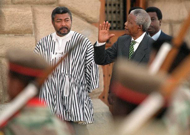 South African President Nelson Mandela waves to spectators as he and President of Ghana Jerry Rawlings inspects 09 July the guard of honour on...