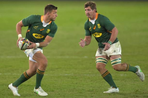 South Africa's fly-half Handre Pollard (L) runs with the ball as South Africa's number eight Kwagga Smith (R) looks on during the first rugby union Test match between South Africa and Georgia at Loftus Versfeld stadium in Pretoria on July 2, 2021. (Photo by Christiaan Kotze / AFP) (Photo by CHRISTIAAN KOTZE/AFP via Getty Images)