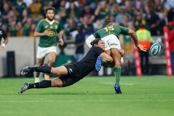 South Africa's fullback Damian Willemse (R) passes the ball while being tackled during the Rugby Championship international rugby match between South Africa and New Zealand at the Mbombela Stadium in Mbombela on August 6, 2022. (Photo by PHILL MAGAKOE / AFP) (Photo by PHILL MAGAKOE/AFP via Getty Images)