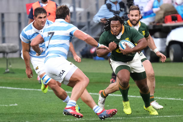 South Africa's hooker Joseph Dweba (C) runs with the ball in front of Argentina's openside flanker Facundo Isa (L) during the Rugby Championship international rugby union Test match between South Africa and Argentina at The Nelson Mandela Bay Stadium in Port Elizabeth on August 14, 2021. (Photo by Michael Sheehan / AFP) (Photo by MICHAEL SHEEHAN/AFP via Getty Images)