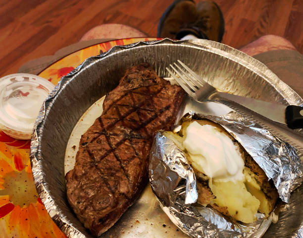 steak and potato dinner resting in mans lap picture
