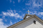 Steeple And Cross Set Against A Blue Sky