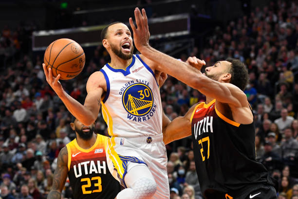 Stephen Curry of the Golden State Warriors drives to the basket against Rudy Gobert of the Utah Jazz during the second half of a game at Vivint Smart...