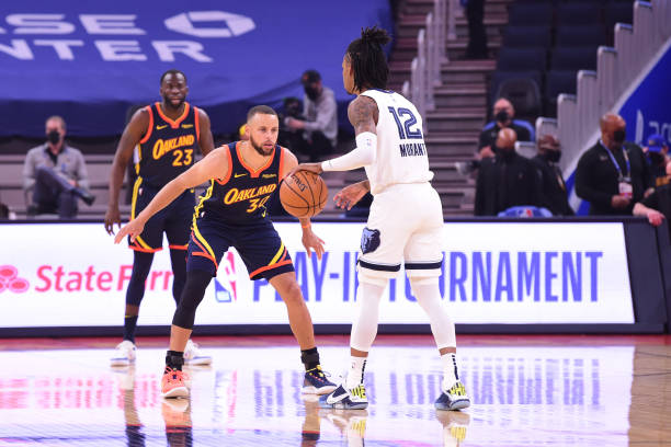 Stephen Curry of the Golden State Warriors plays defense on Ja Morant of the Memphis Grizzlies during the 2021 NBA Play-In Tournament on May 21, 2021...