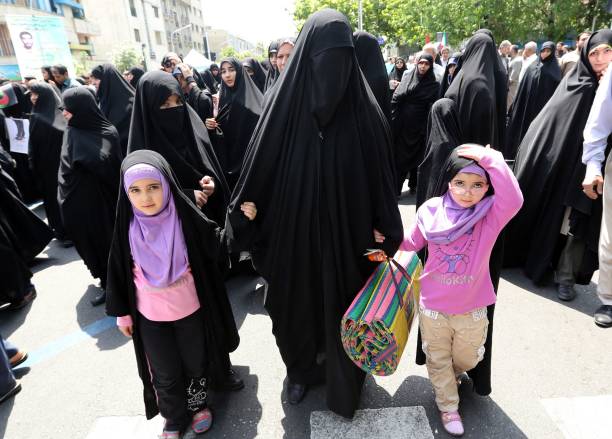 A supporter of Iranian religious hardliners with two children takes part in a demonstration after the weekly Friday prayer in Tehran on May 16 2014...