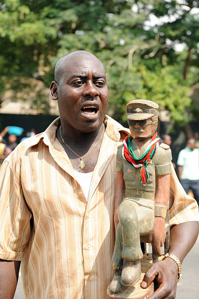 A supporter of the opposition National Democratic Congress celebrates with a statue of former military leader Jerry Rawlings shortly after...