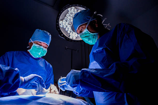 cirurgiões performing complicado cirurgia no paciente em sala de cirurgia - cirurgia plástica - fotografias e filmes do acervo