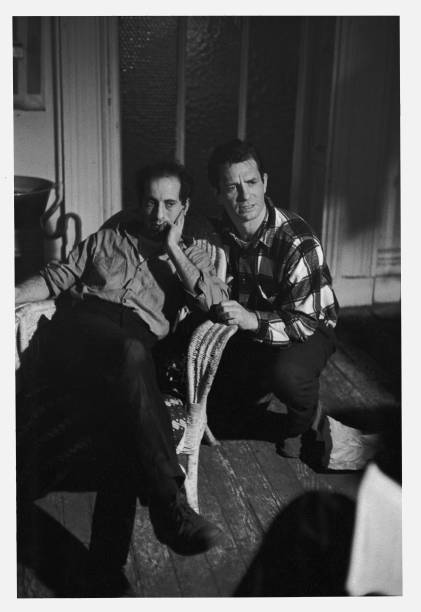 Swiss-born American photographer and film director Robert Frank sits with head on hand and American Beat poet Jack Kerouac kneels next to him as they...