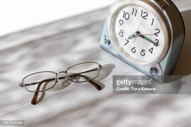 table clock eyeglasses desk window morning
