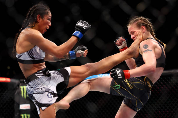 Taila Santos of Brazil kicks Valentina Shevchenko of Kyrgyzstan in their flyweight title bout during UFC 275 at Singapore Indoor Stadium on June 12,...